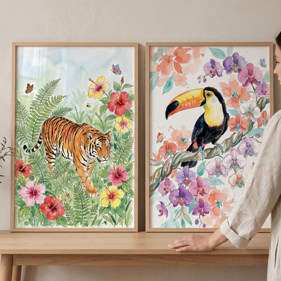 Vibrant jungle animal wall art set of 2 with a tiger and toucan among tropical flowers in light wood frames.
