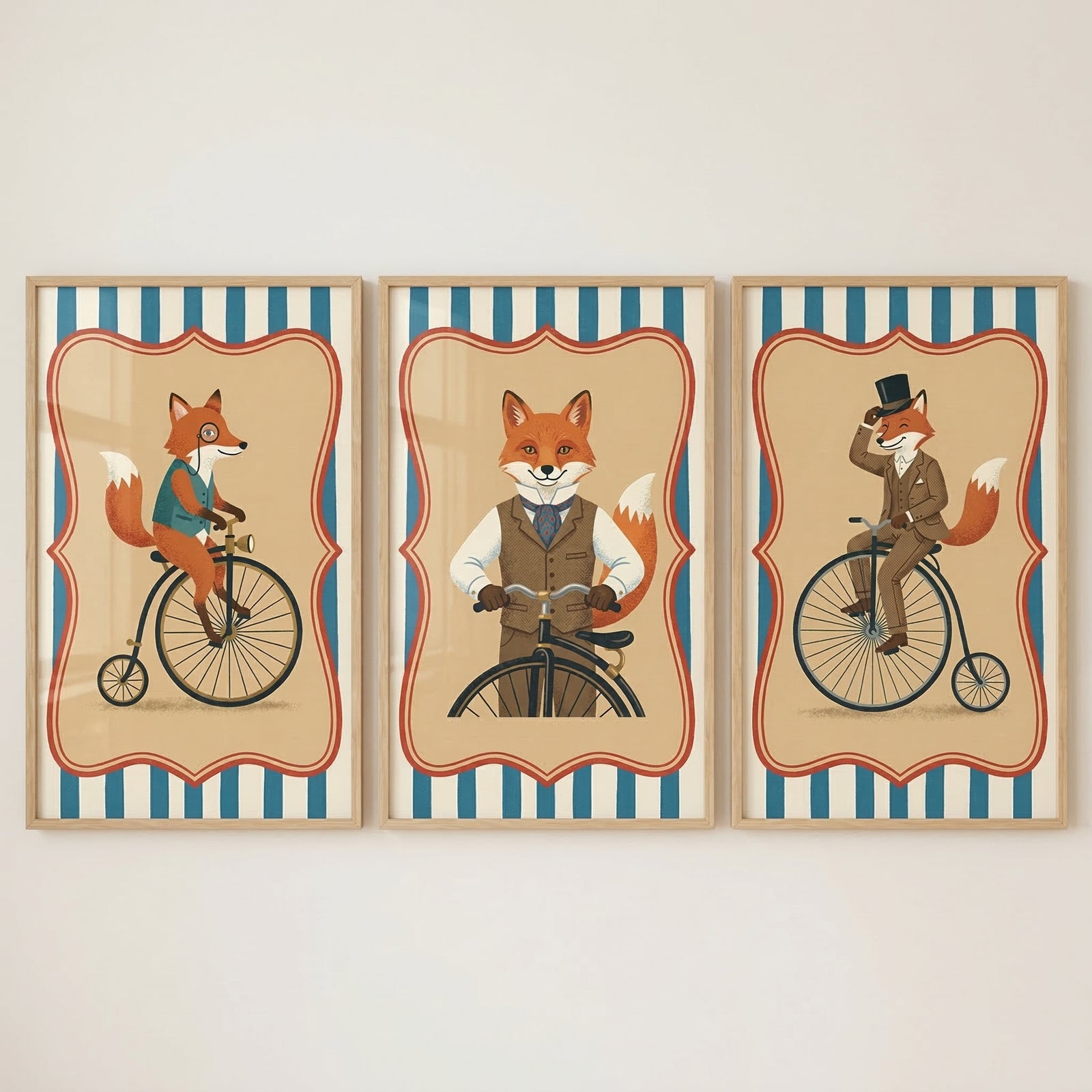 Three side-by-side framed illustrations of anthropomorphic foxes dressed in vintage Victorian-style clothing. Each piece features a tan background with a red-outlined scalloped border and blue and white striped accents at the top and bottom. The left illustration shows a fox in a teal vest and monocle riding a penny-farthing bicycle. The center illustration features a fox in a brown waistcoat facing forward behind handlebars. 