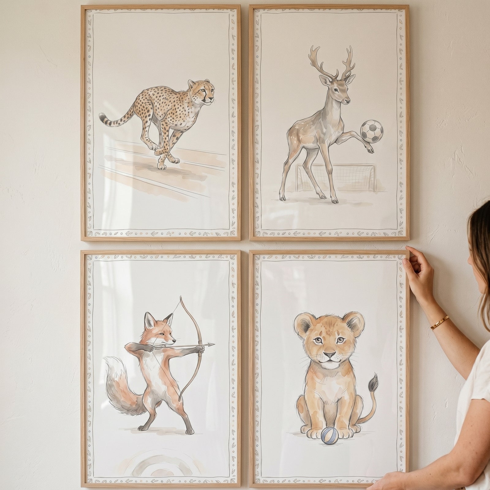 Vine border sports animals wall art set of 4 shows a running cheetah, soccer deer, archery fox, and sitting lion cub.