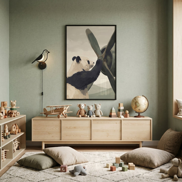 Vintage aircraft mechanic panda wall art on a sage green wall above a wooden sideboard with toys and floor pillows.
