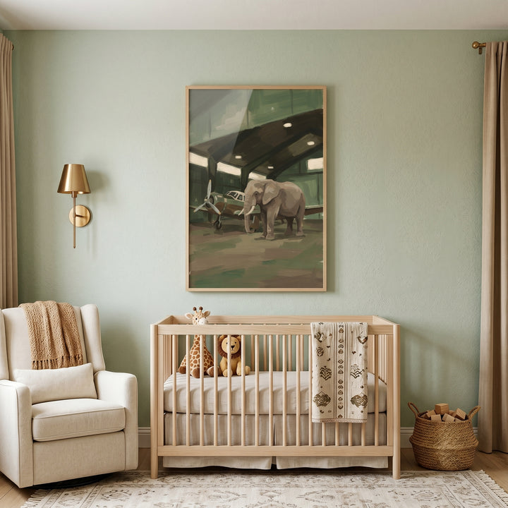 Sage nursery with a light wood crib and white armchair. Above hangs vintage airplane hangar elephant wall art.