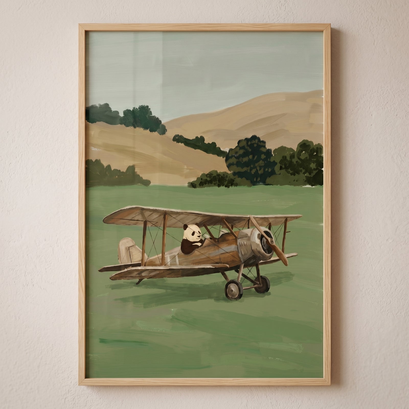 Framed vintage biplane pilot panda wall art of a panda in an airplane on a green field with rolling hills behind it.