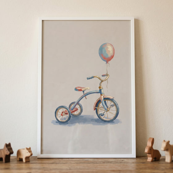 Framed vintage blue balloon tricycle wall art on a wooden surface with small wooden animal toys.