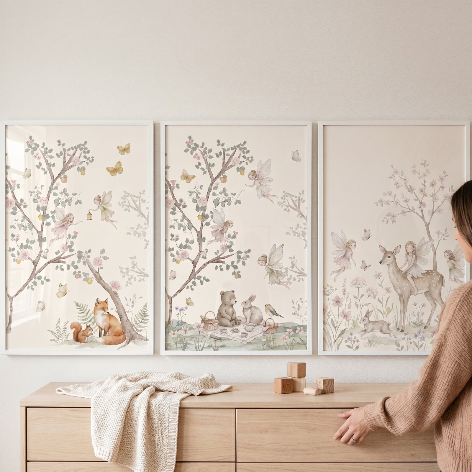Vintage botanical winged fairies wall art set of 3 featuring forest animals hangs above a light wood dresser.