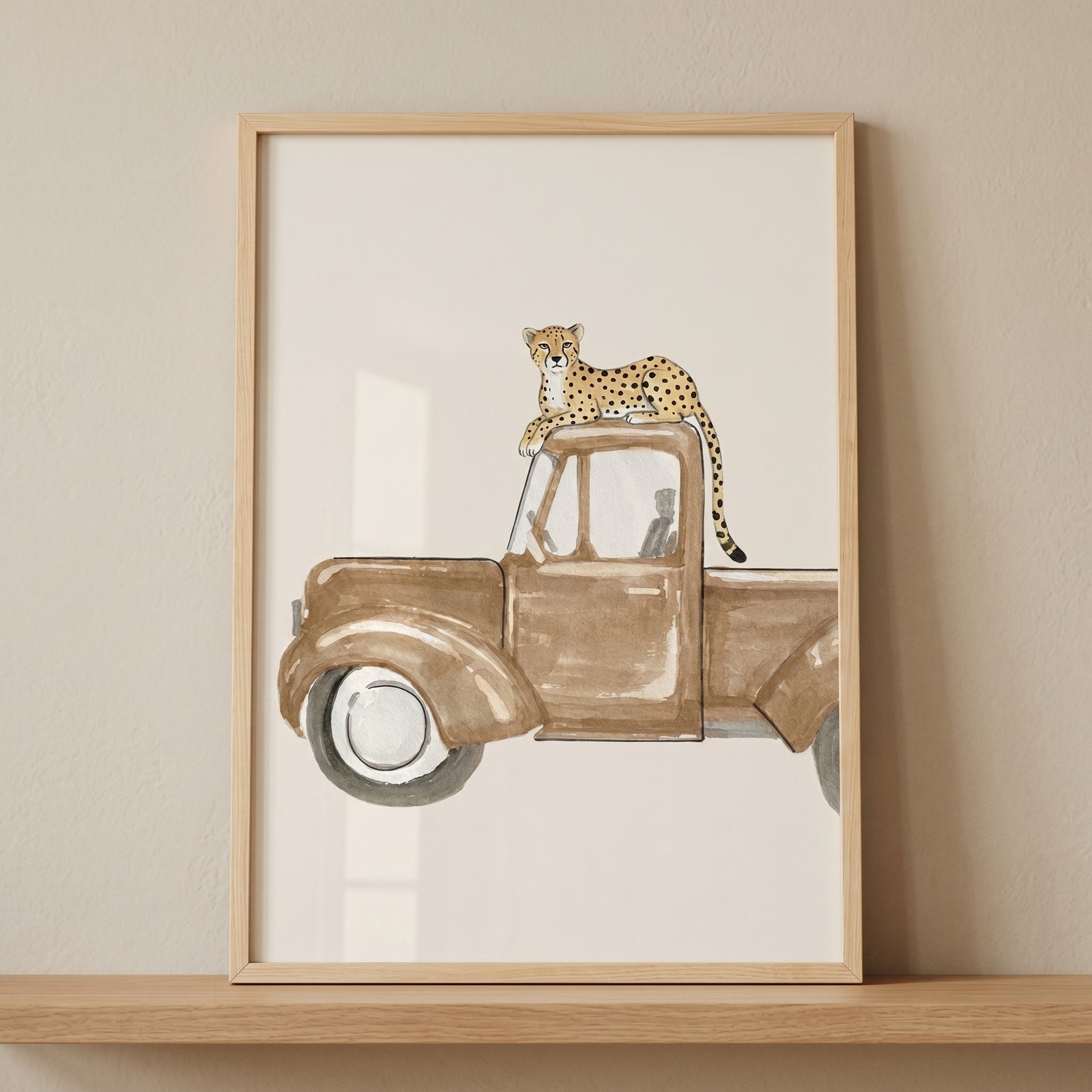 Framed vintage brown truck cheetah wall art showing a spotted cheetah resting on the roof of a classic pickup truck.