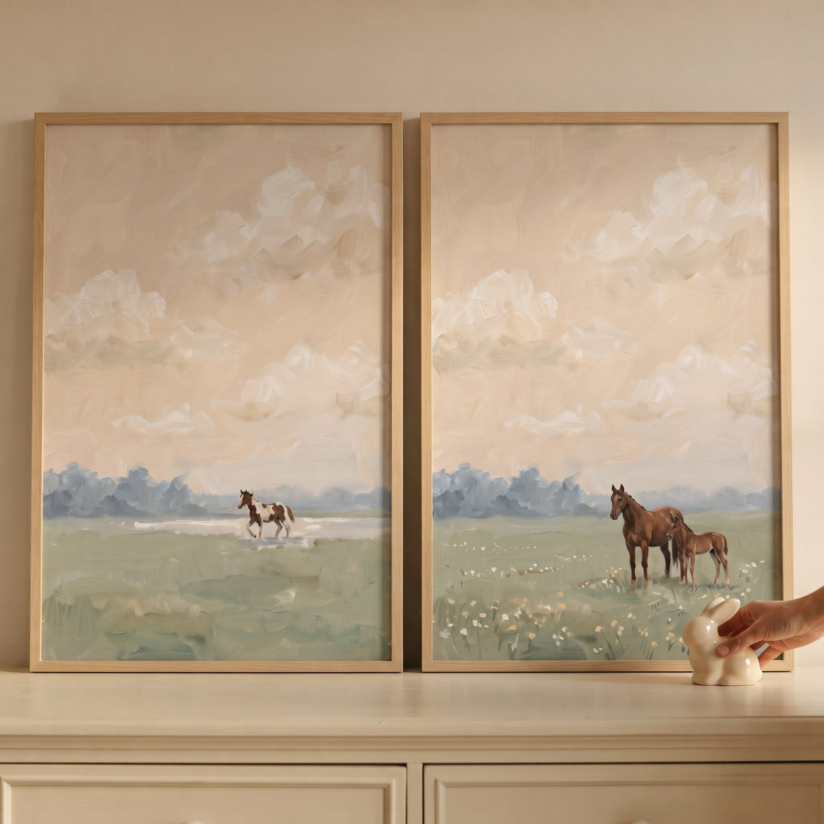 Vintage equestrian landscape horse wall art set of 2 depicts horses in a field under a cloudy sky on a light dresser.