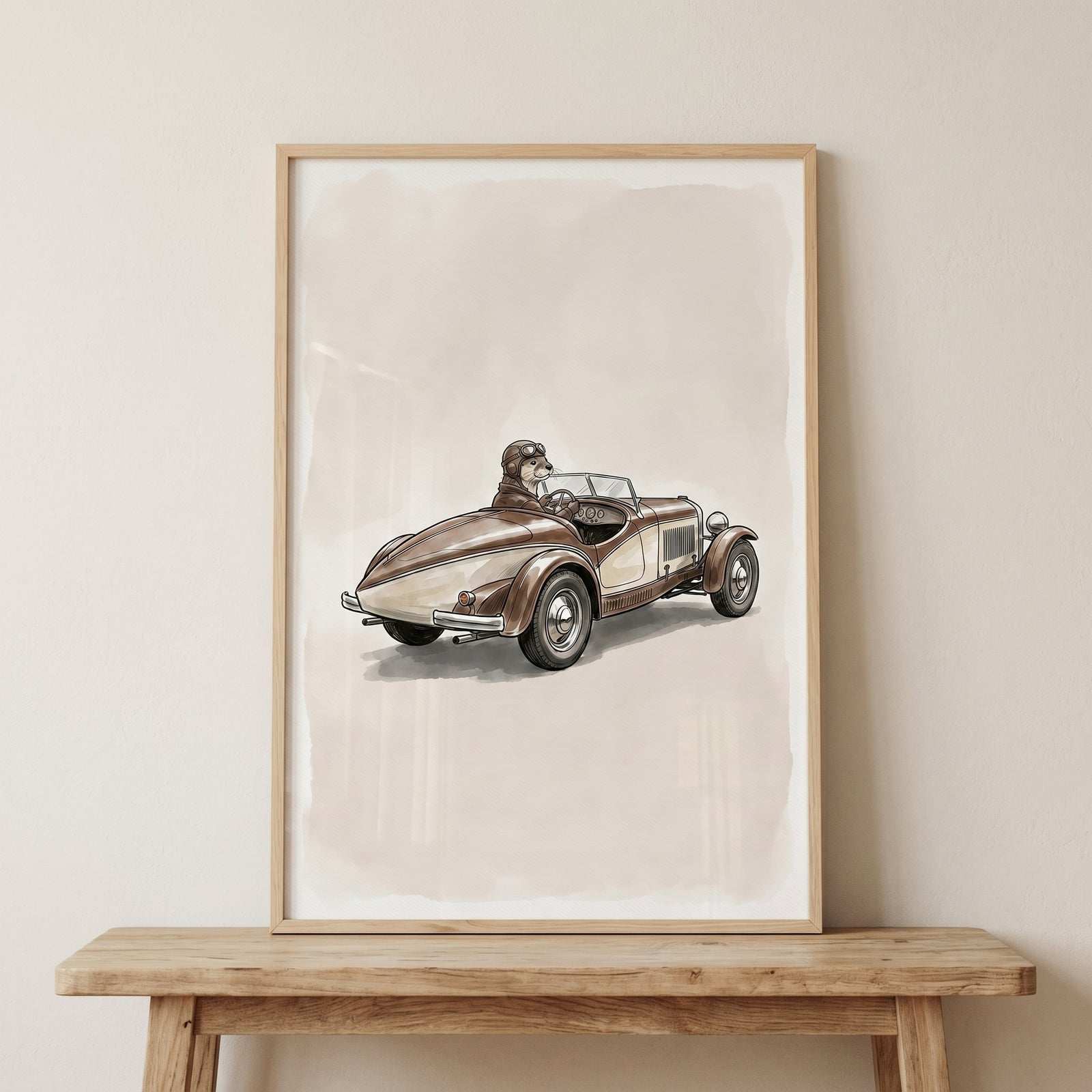 Framed vintage goggles driving otter wall art displayed on a neutral wall above a wooden console table.