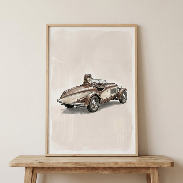 Framed vintage goggles driving otter wall art displayed on a neutral wall above a wooden console table.