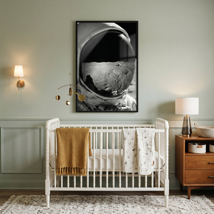 Vintage lunar landing astronaut wall art hangs above a white crib in a sage green nursery with a wooden dresser.