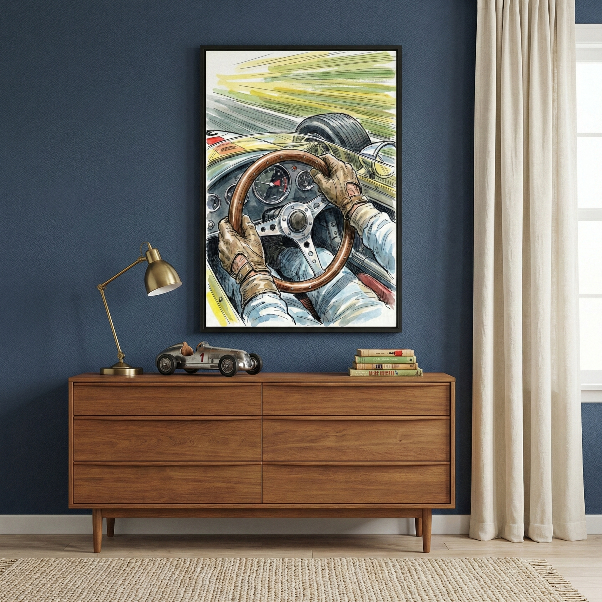 A stylish room features a wooden sideboard against a dark blue wall, adorned with a large framed artwork depicting a vintage race car driver's perspective. On the sideboard, a brass desk lamp and a model race car sit beside a small stack of books. Cream-colored curtains frame a window, adding a touch of warmth to the space.
