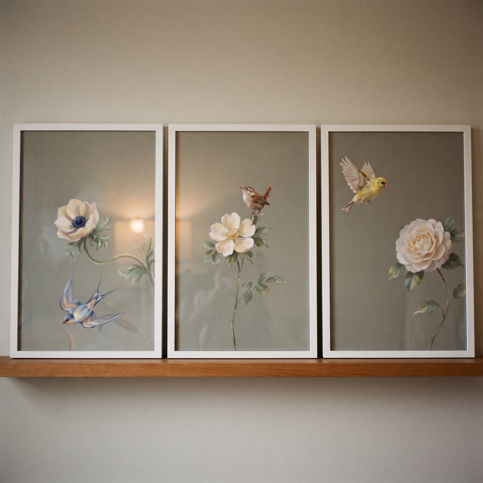 Vintage sage floral bird floral wall art set of 3 shows blue, brown, and yellow birds and white flowers on a shelf.