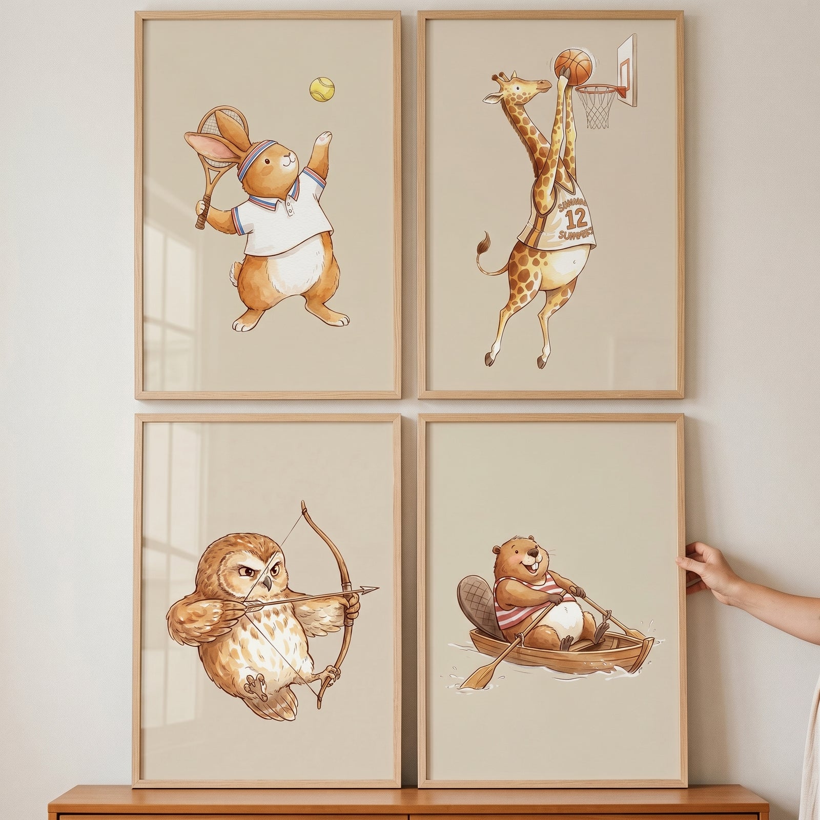 Vintage storybook athletic animals artwork set of 4 with a tennis rabbit, basketball giraffe, archer owl, and rowing beaver.