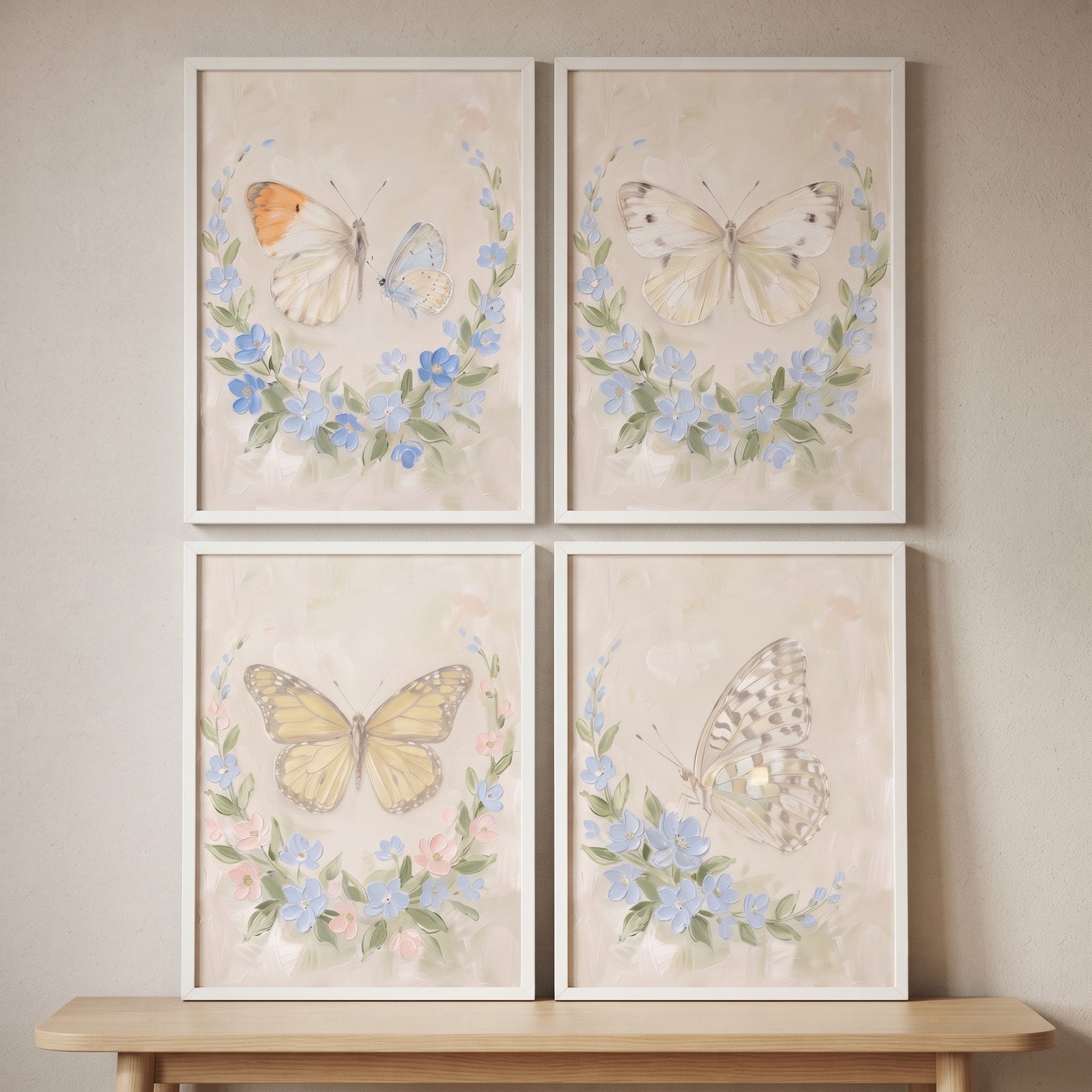 Vintage wildflower wreath butterfly wall art set of 4 in white frames on a beige wall above a light wood table.