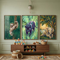 A children's room features three framed animal-themed illustrations on a sage green wall. One depicts a sloth in a tree, another a dark jungle cat, and the third a young elephant at sunset. Below, a wooden console table holds colorful building blocks and carved wooden animal figures. Woven baskets and scattered blocks are on a patterned rug. A small plant in a macrame hanger is suspended from the ceiling. The space has a natural, playful feel with wooden accents and jungle-inspired decor.
