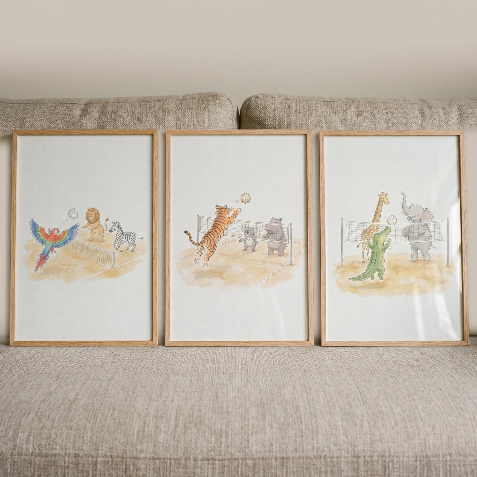 Volleyball playing safari animals wall art set of 3 in wood frames featuring animal illustrations on a neutral sofa.