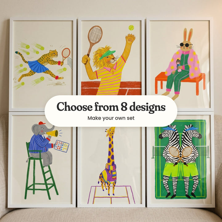 Six tennis animal prints in white frames in two rows leaning on a beige sofa: a cheetah lunging at a ball, a lion serving, a bunny in a pink jacket on a bench, an elephant umpire with a megaphone, a giraffe in a striped scarf and two zebras with crossed rackets, with a label reading Choose from 8 designs, Make your own set