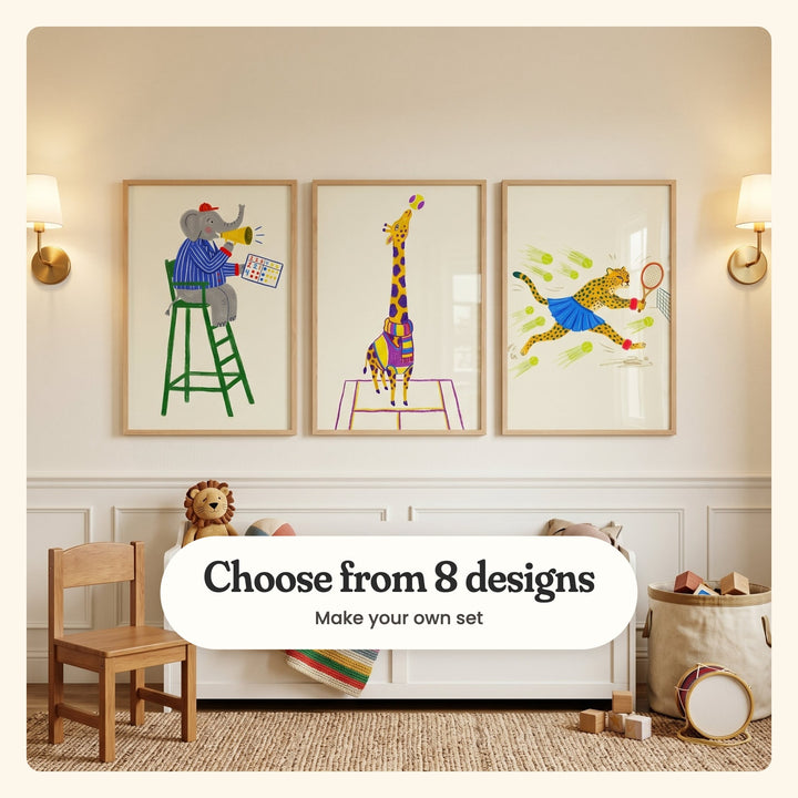 Cream playroom wall with three tennis animal prints in light wood frames between two brass sconces, above a white toy bench with a plush lion and a striped blanket, beside a wooden kids' chair: an elephant umpire with a megaphone, a giraffe in a scarf and a cheetah lunging at a ball, labeled Choose from 8 designs, Make your own set