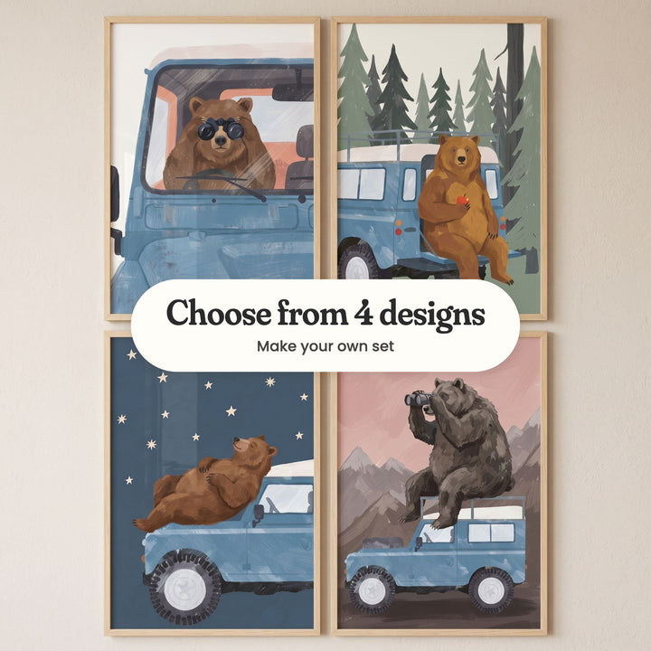 Four bear and blue truck prints in light wood frames in two rows on a cream wall: a bear at the wheel looking through binoculars, a bear holding an apple on the back step, a bear lying on the hood under the stars and a bear on the roof with binoculars, with a label reading Choose from 4 designs, Make your own set