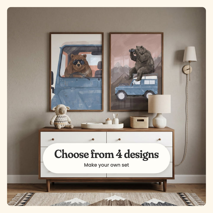 Nursery with two bear and blue truck prints in walnut frames above a walnut and white dresser with a knit lamb, a woven basket and a linen lamp, beside a brass wall sconce and a mountain-pattern rug: a bear at the wheel looking through binoculars and a bear on the roof with binoculars under a pink sky, labeled Choose from 4 designs, Make your own set