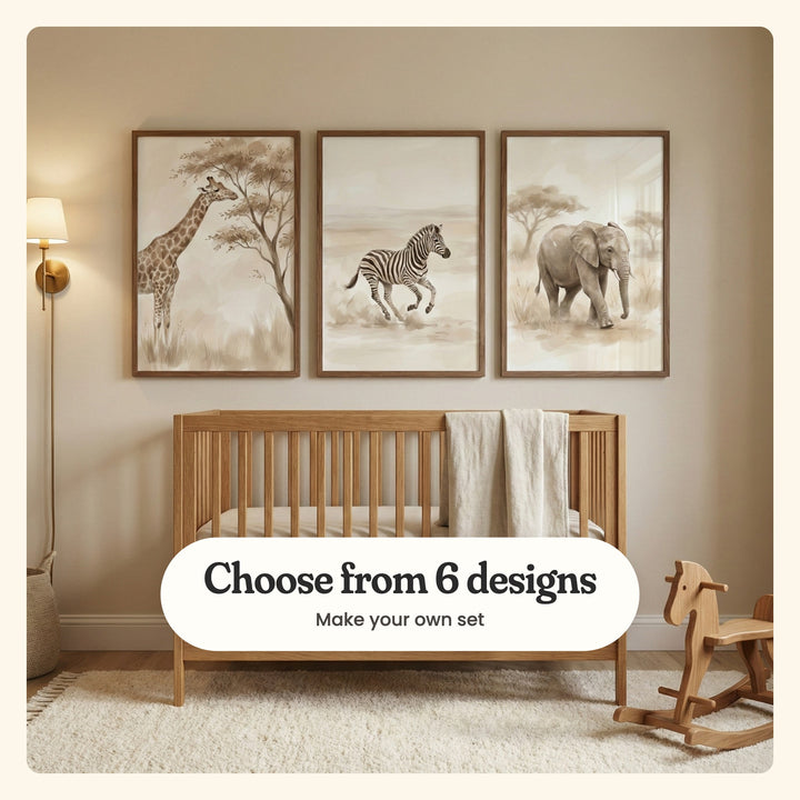 Three safari animal prints in dark wood frames above an oak crib with a linen throw, beside a brass sconce and a rocking horse: a giraffe eating from an acacia, a running zebra and a young elephant under acacias, labeled Choose from 6 designs, Make your own set
