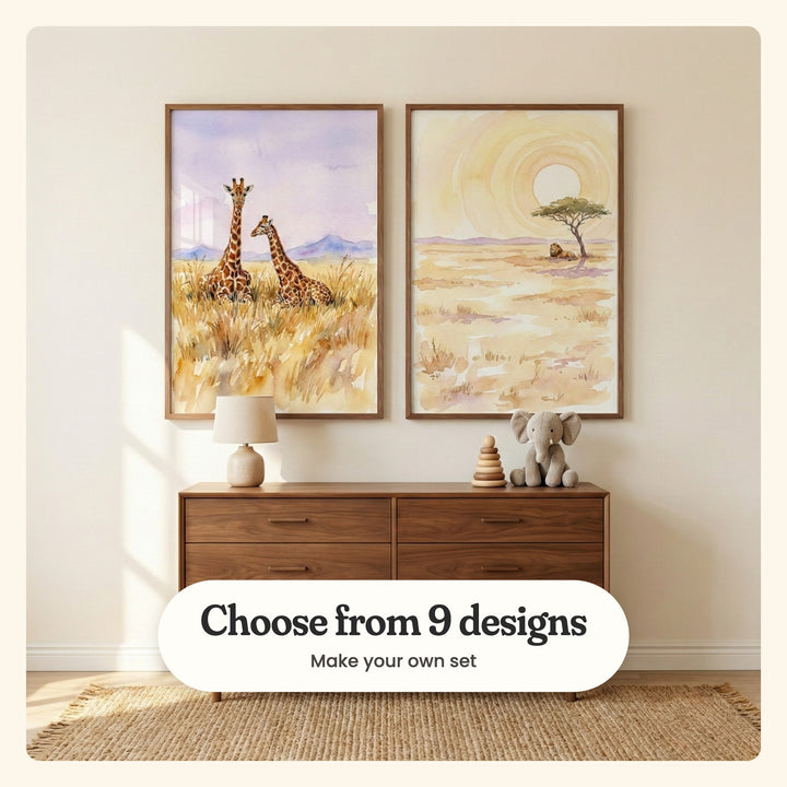 Cream room with two savanna prints in dark wood frames above a walnut dresser with a small lamp, a stacking toy and a plush elephant: Savanna Serenity and Golden Savanna King, labeled Choose from 9 designs, Make your own set