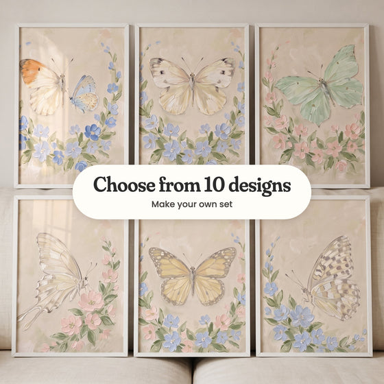 Six butterfly prints in white frames in two rows leaning on a cream sofa: an orange-tip and a small blue butterfly in a blue wreath, a cream white butterfly in a blue wreath, a mint green butterfly in a blush wreath, a cream swallowtail with blush blossoms, a soft yellow butterfly in a blush and blue wreath and a spotted butterfly with blue blossoms, with a label reading Choose from 10 designs, Make your own set