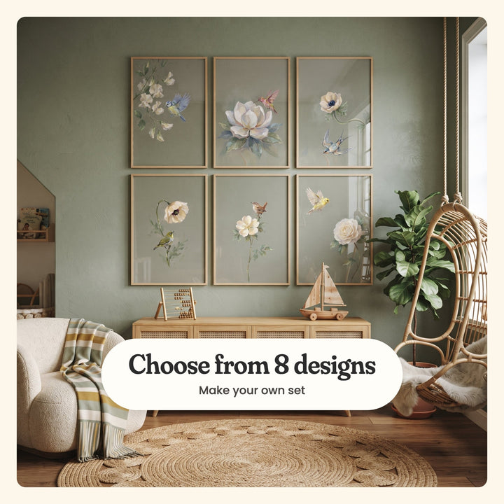 Sage nursery wall with six songbird prints in light wood frames in two rows above a rattan sideboard with a wooden abacus and sailboat, beside a hanging rattan chair: a blue tit, a hummingbird, a swallow under an anemone, a white-eye under a poppy, a wren and a yellow finch, labeled Choose from 8 designs, Make your own set