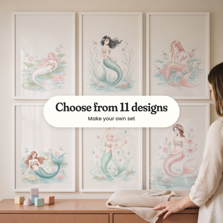 Six mermaid prints in white frames in two rows on a cream wall, beside a woman resting a hand on a terracotta dresser with pastel blocks: a pink-haired mermaid on lily pads, a dark-haired mermaid among cattails, a mermaid resting her chin on her hands, a mermaid lying in water lilies, a mermaid reaching for butterflies and a mermaid in a flower crown, with a label reading Choose from 11 designs, Make your own set