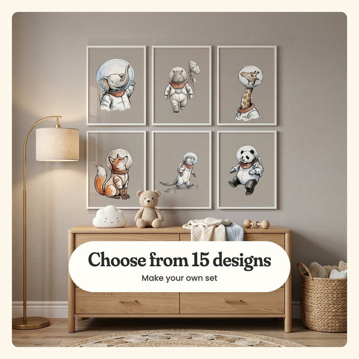 Taupe nursery with six astronaut animal prints in white frames in two rows above a light wood dresser with a cloud lamp and a teddy bear, beside a brass floor lamp: Stellar Trunk Traveler, Cosmic Hippo Explorer, Space Suit Giraffe, Stellar Space Fox, Cosmic Otter Explorer and Space Panda Pilot, labeled Choose from 15 designs, Make your own set