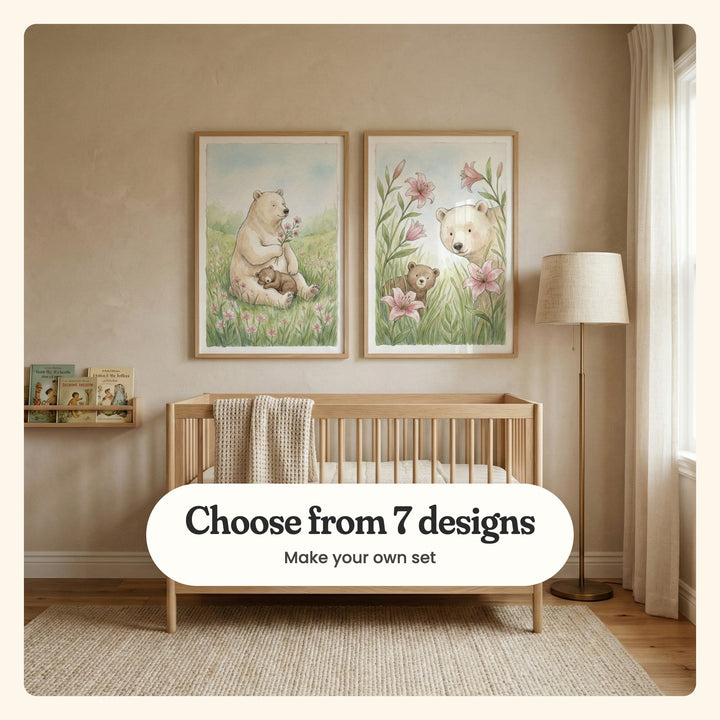 Nursery with two bear and cub prints in light wood frames above a light wood crib with a knit blanket, beside a book ledge and a floor lamp: a bear with a cub asleep in her lap and two bears among pink lilies, labeled Choose from 7 designs, Make your own set