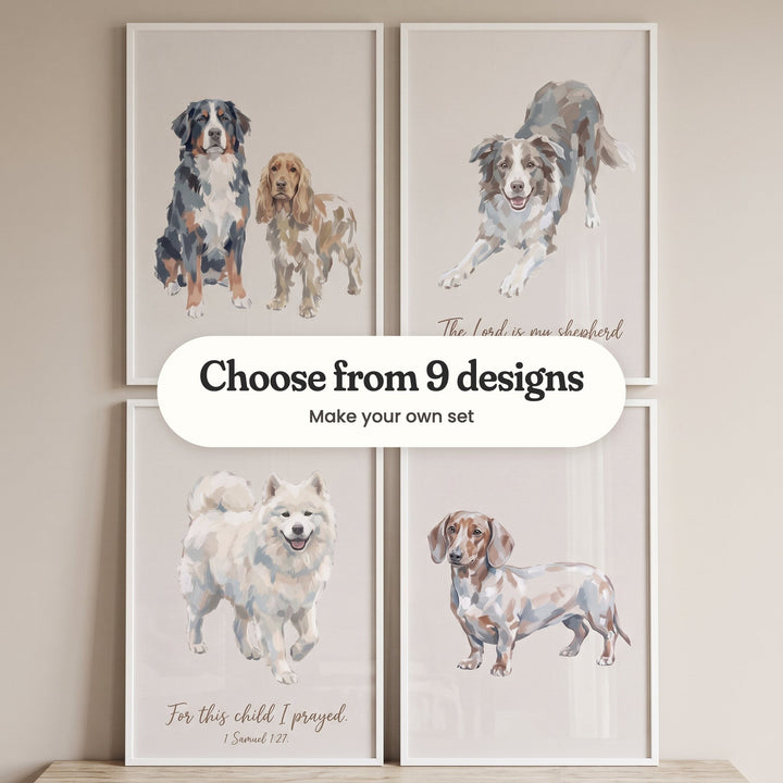 Four beige dog prints in white frames in two rows on a light wood top against a beige wall: a Bernese mountain dog beside a cocker spaniel, a border collie in a playful bow with the words The Lord is my shepherd, a smiling Samoyed with the verse For this child I prayed and a dapple dachshund, with a label reading Choose from 9 designs, Make your own set