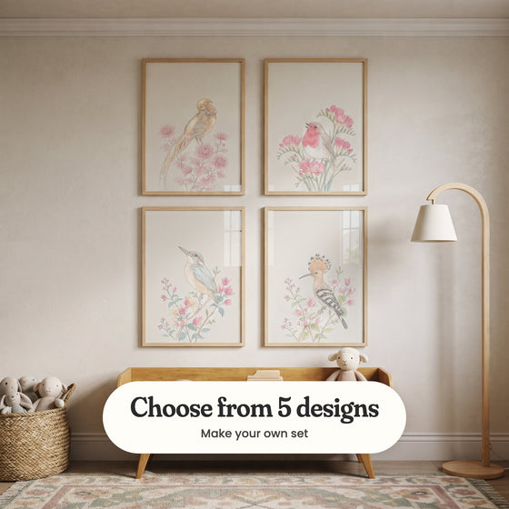Cream room with four bird prints in light wood frames in two rows above a light wood bench with a plush lamb, beside a curved floor lamp and a basket of plush toys: Soft Petal Perch, Spring Songbird, Serene Kingfisher Bloom and Hoopoe Among Blossoms, with a label reading Choose from 5 designs, Make your own set