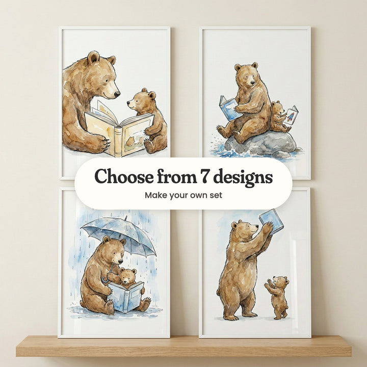 Four reading bear prints in white frames leaning on a wooden wall shelf: a bear and cub sharing a picture book, a bear and cub reading on a rock in a splashing stream, a bear holding an umbrella over a reading cub and a bear holding a blue book up high, with a label reading Choose from 7 designs, Make your own set