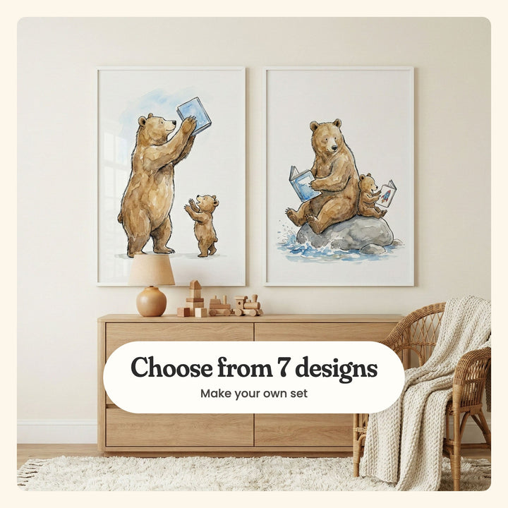Nursery with two reading bear prints in white frames above an oak dresser with a ceramic lamp, wooden blocks and a toy train, beside a rattan chair with a knit throw and a shaggy rug: a bear holding a blue book up high for a cub and a bear and cub reading on a rock in a stream, labeled Choose from 7 designs, Make your own set