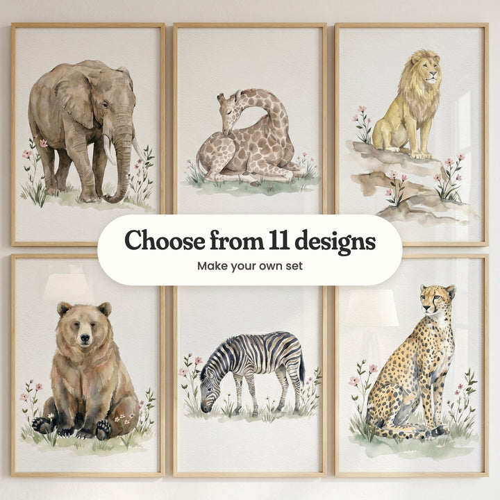 Six watercolor-style animal prints in light wood frames: an elephant in pink wildflowers, a sleeping giraffe, a lion on the rocks, a bear, a grazing zebra and a cheetah, with a label reading Choose from 11 designs, Make your own set