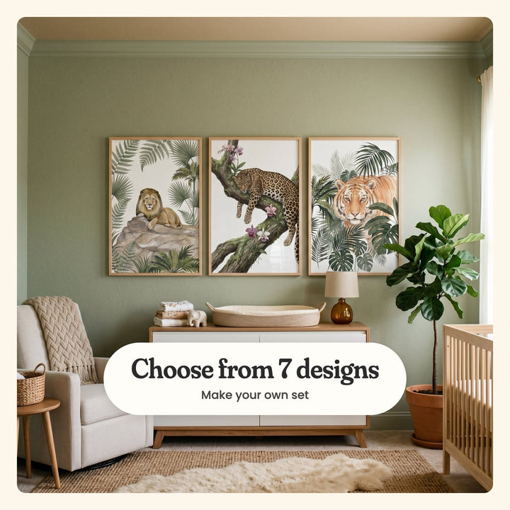 Sage green nursery with three animal prints in light wood frames above a white and wood changing dresser with a lamp, beside an armchair with a knit throw, a fiddle leaf fig and a crib: Majestic Jungle Lion, Spotted Floral Repose and Majestic Jungle Gaze, labeled Choose from 7 designs, Make your own set