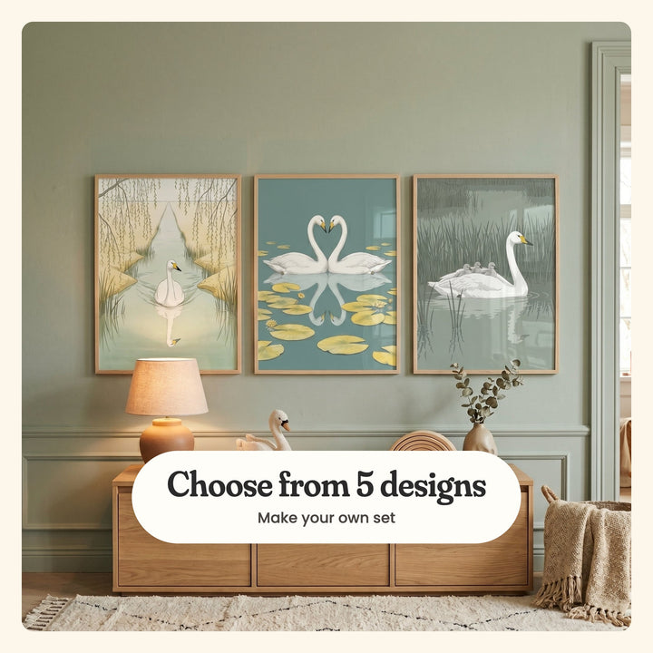 Sage green panelled room with three swan prints in light wood frames above a light wood console with a glowing table lamp, a swan toy and a vase of eucalyptus: Serene Swan Reflection, Eternal Swan Love and Swan Family Voyage, labeled Choose from 5 designs, Make your own set