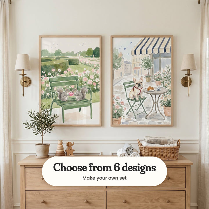 Cream panelled nursery with two Paris prints in light wood frames between two brass wall lamps, above a light wood dresser with a small olive tree, wooden toys and a basket of rolled towels, between linen curtains: Squirrel Garden Picnic and Parisian Cafe Dog, with a label reading Choose from 6 designs, Make your own set