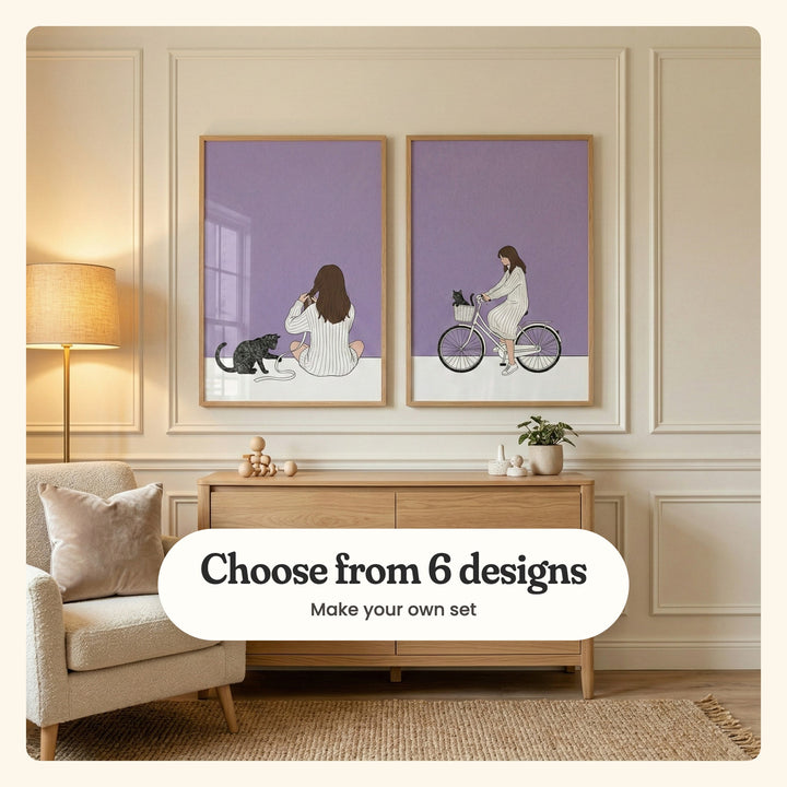 Cream panelled room with two girl and cat prints in light wood frames above a light wood sideboard with a small plant, beside a floor lamp, a cream armchair with a cushion and a jute rug: Lavender Morning Braid and Lavender Cycle Companion, labeled Choose from 6 designs, Make your own set