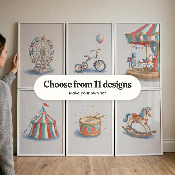 Six vintage carnival prints in white frames leaning against a wall on a wood floor, with a woman holding one: a Ferris wheel, a tricycle, a carousel, a striped big top, a drum and a rocking horse, with a label reading Choose from 11 designs, Make your own set