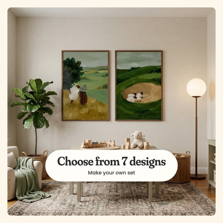 Cream playroom with two golfing sheep prints in dark wood frames above a kids' table with a wooden toy train, blocks and a plush lamb, beside a fiddle leaf fig, an armchair and a globe floor lamp: Woolly Tee Time and Woolly Sand Trap, labeled Choose from 7 designs, Make your own set