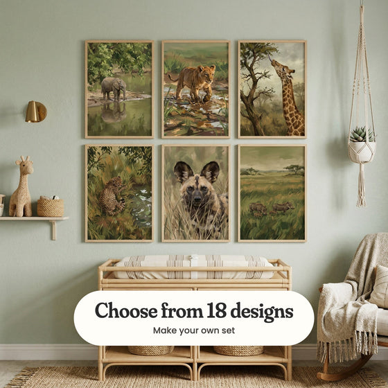 Sage green nursery with six safari animal prints in light wood frames in two rows above a rattan changing table, beside a rocking chair, a hanging plant and a plush giraffe on a shelf: Gentle River Calf, Golden Cub Stride, The Long Reach, Spotted Serenity, Wild Dog in the Grass and Savanna Family Life, with a label reading Choose from 18 designs, Make your own set