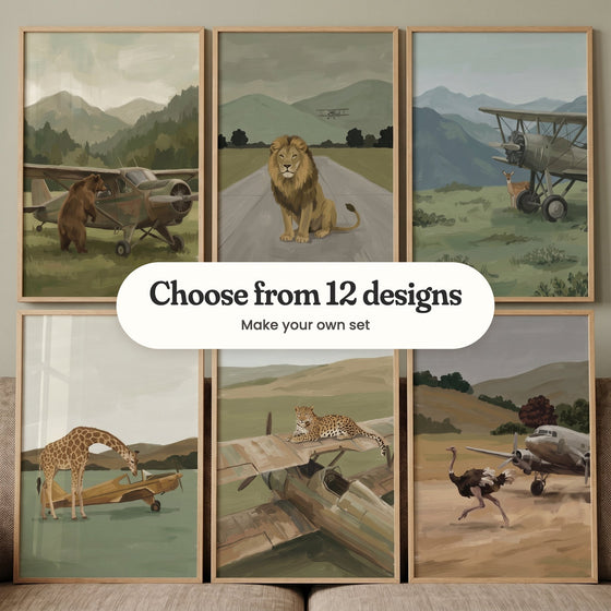 Six airfield animal prints in light wood frames in two rows propped on a cushioned seat against a grey-green wall: a bear standing up against a plane before misty mountains, a lion sitting on a runway with a biplane overhead, a fawn beside a biplane in a meadow, a giraffe peeking into a small plane, a leopard lying on an old wrecked wing and an ostrich racing a silver airliner, with a label reading Choose from 12 designs, Make your own set