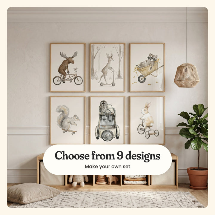 Playroom with six woodland animal prints in light wood frames in two rows above a low cube shelf with fabric bins, knit toys, stacking rings and a wooden deer, beside a fiddle-leaf fig and a floor cushion: a moose on a tandem bike, a deer on a scooter, a raccoon napping in a wheelbarrow, a squirrel on a skateboard, an owl on a pedal car and a bunny on a tricycle, labeled Choose from 9 designs, Make your own set