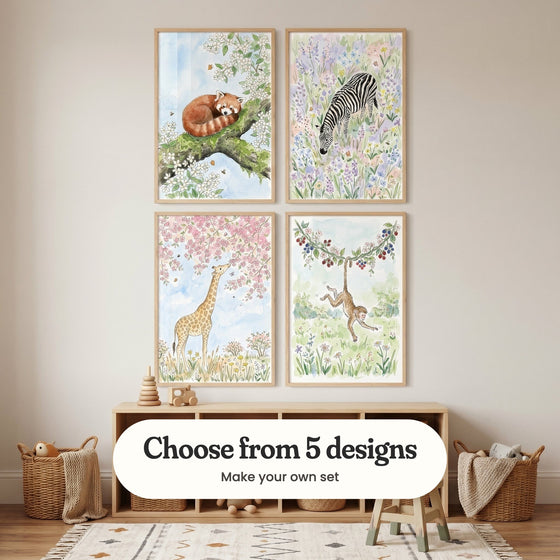 Cream room with four animal prints in light wood frames in two rows above a low wood cube shelf with a stacking toy and a toy car, beside woven baskets and a small wooden stool: Spring Blossom Nap, Striped Garden Bliss, Giraffe Blossom Dream and Playful Berry Monkey, with a label reading Choose from 5 designs, Make your own set