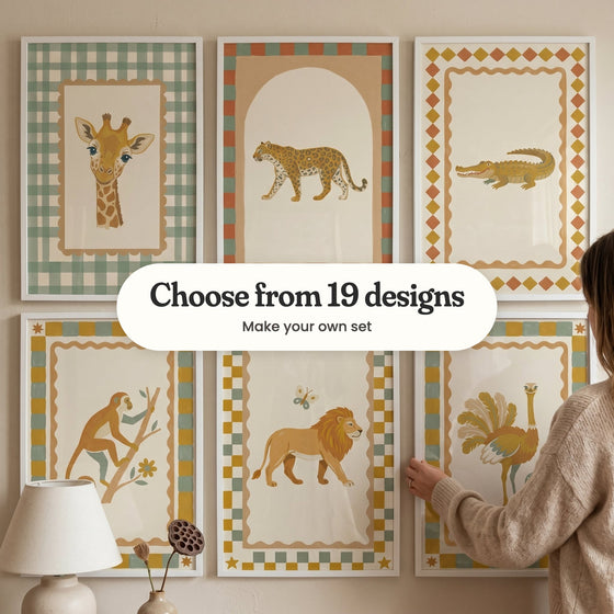 Six safari animal prints in white frames in two rows, with a woman holding one and a lamp and a dried lotus pod in front: a giraffe inside a sage gingham border, a leopard walking under an arch, a crocodile inside a diamond border, a monkey climbing a branch, a lion walking with a butterfly and an ostrich with fanned feathers, with a label reading Choose from 19 designs, Make your own set