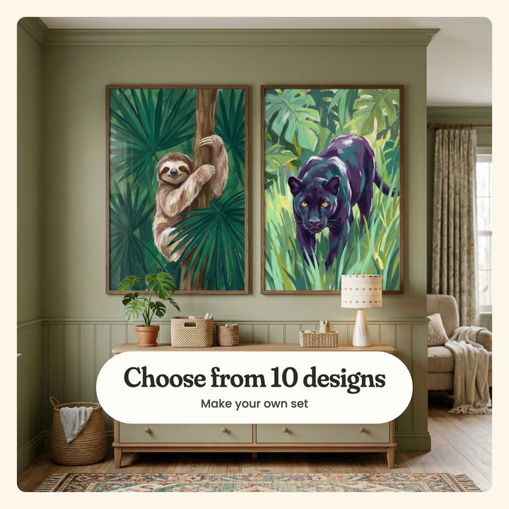 Sage green nursery with two jungle prints in dark wood frames above a sage dresser with a potted plant, baskets and a small lamp, beside an armchair and a patterned curtain: Happy Jungle Sloth and Midnight Jungle Prowl, labeled Choose from 10 designs, Make your own set
