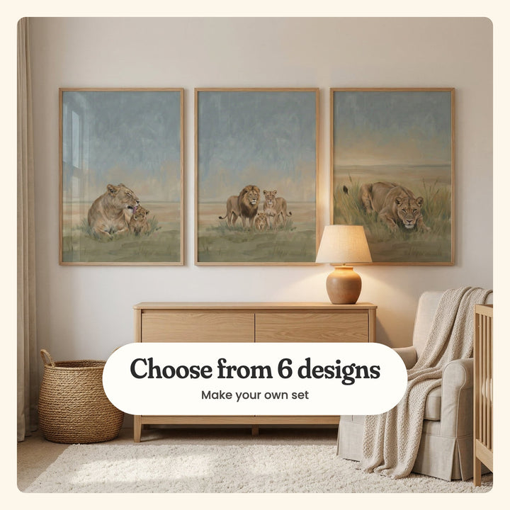 Nursery with three lion prints in light wood frames above a light oak dresser with a ceramic lamp, beside a cream armchair with a knit throw and the edge of a crib on a shaggy cream rug: a lioness grooming her cub, a lion family of three and a lioness crouching in tall grass, labeled Choose from 6 designs, Make your own set