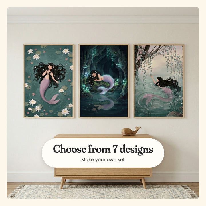Cream room with three mermaid prints in light wood frames above a low light wood cabinet with a wooden whale, over a patterned rug: Serene Pond Maiden, Glowing Mermaid Dream and Willow Pond Mermaid, labeled Choose from 7 designs, Make your own set