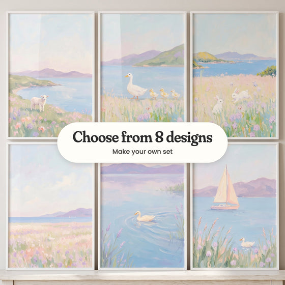 Six coastal meadow prints in white frames standing on a white ledge: a lamb above a bay, a duck leading ducklings, two bunnies in bloom, a wide pastel meadow, a duck on a lilac lake and a pink-sailed sailboat, with a label reading Choose from 8 designs, Make your own set